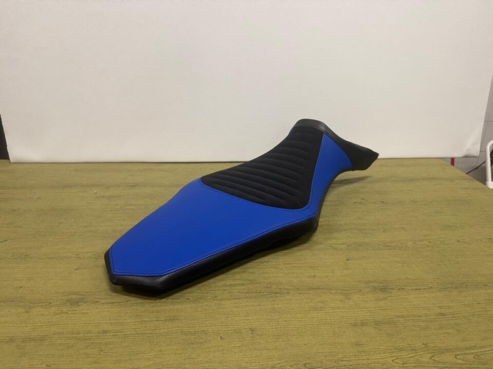 Sella moto rivestita in blu e nero con inserto centrale a costine, vista laterale